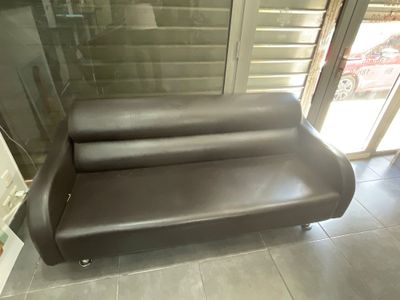 un canapé en cuir marron placé devant une porte-fenêtre coulissante