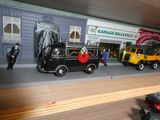 un camion miniature posé sur une étagère devant un garage
