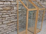 two wooden and glass display cases against a stone wall