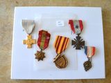 une photo montrant un assortiment de médailles disposées sur une assiette blanche