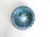 a small blue bowl sitting on a white surface