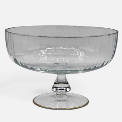 a clear glass bowl with a gold rim on a white surface