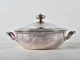 a silver pot with a lid sitting on a table
