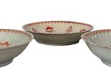 three white and red bowls with designs on them on a white surface