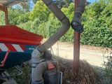 a hose attached to the side of a building next to a pile of hay