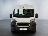the front view of a white van parked in a white room
