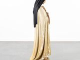 a statue of a woman wearing a veil and standing on a piece of wood