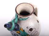a white vase with a blue and green design on it