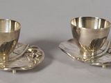 paire de tasses et soucoupes en métal argenté, posées sur une soucoupe