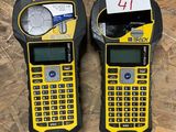 two yellow and black cell phones sitting on top of a wooden floor