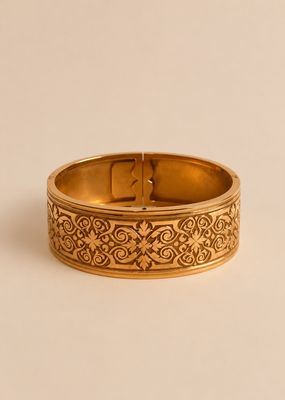 gros plan d'un bracelet en or sur une surface blanche
