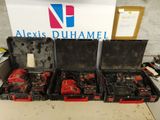 trois outils rouges et noirs dans un coffret posé sur une table
