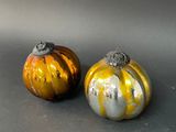 two small pumpkins sitting on a table next to each other