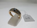 Gros plan sur une bague en or ornée d'une pierre noire