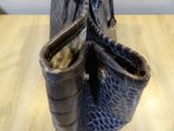 a black purse with a pair of boots inside of it