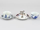three small cups and saucers sitting on top of a table