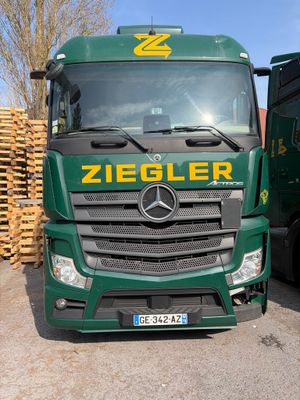 deux camions verts garés l'un à côté de l'autre sur un parking
