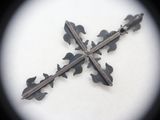 a cross made out of metal on a white surface