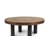 a round wooden table with four black legs and a circular wooden table top
