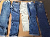 cinq paires de jeans posées sur une boîte en carton