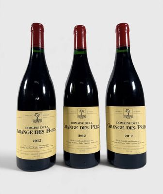trois bouteilles de vin rouge posées l'une à côté de l'autre sur une surface blanche