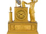 une horloge en or surmontée d'une statue