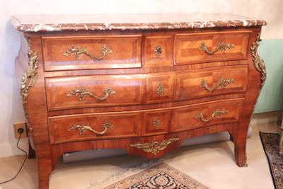 a wooden chest of drawers with a marble top
