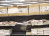 many stacks of papers on the shelves in the store