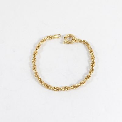 gros plan d'un bracelet en chaîne en or sur fond blanc