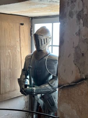 un homme en armure, debout dans une embrasure de porte