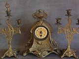 trois bougies et une horloge posées sur une table