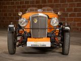 an orange car parked in front of a brick wall