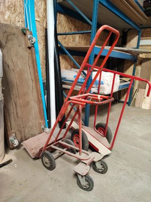 un diable rouge posé devant une pile de cartons
