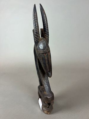 un gros plan sur une sculpture représentant une tête de chèvre avec des cornes