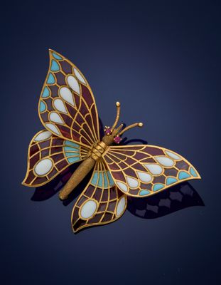 une image représentant une broche en forme de papillon aux ailes bleues et dorées