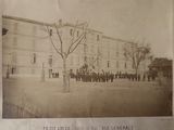 an old black and white photo of a group of people standing in front of a building