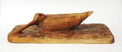 carved wooden duck figurine on a wooden base with a white background