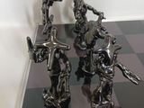 four metal figurines of knights on a chess board