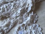 a close up of a white crocheted scarf on a table