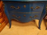 une commode bleue avec un plateau en verre
