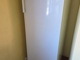 a white refrigerator in the corner of a room