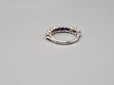 a close up of a diamond and sapphire ring on a table