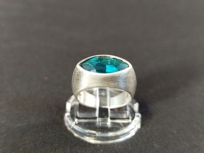 un gros plan d'une bague en argent sertie d'une topaze bleue