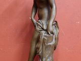 statue en bronze représentant un garçon assis sur un rocher, le corps enveloppé d'un tissu