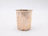 a silver cup that is sitting on a white surface