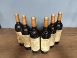 six bottles of wine sitting on top of a wooden table