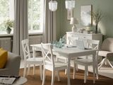 a white table and chairs in a room with green walls