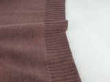 the back of a brown sweater on a white table