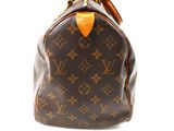 a close up of a brown louis vuitton handbag on a white background