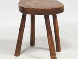 une image représentant un petit tabouret en bois posé sur une surface blanche